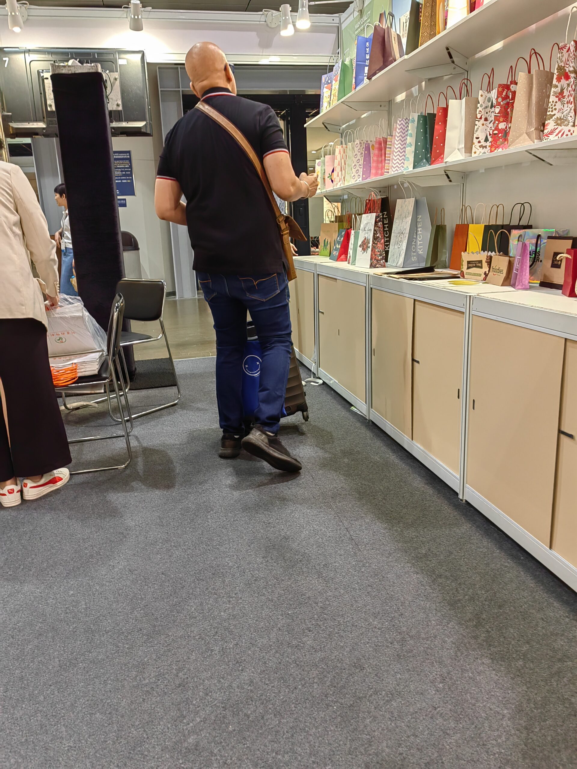 Exhibition visitor reviewing packaging samples at the booth