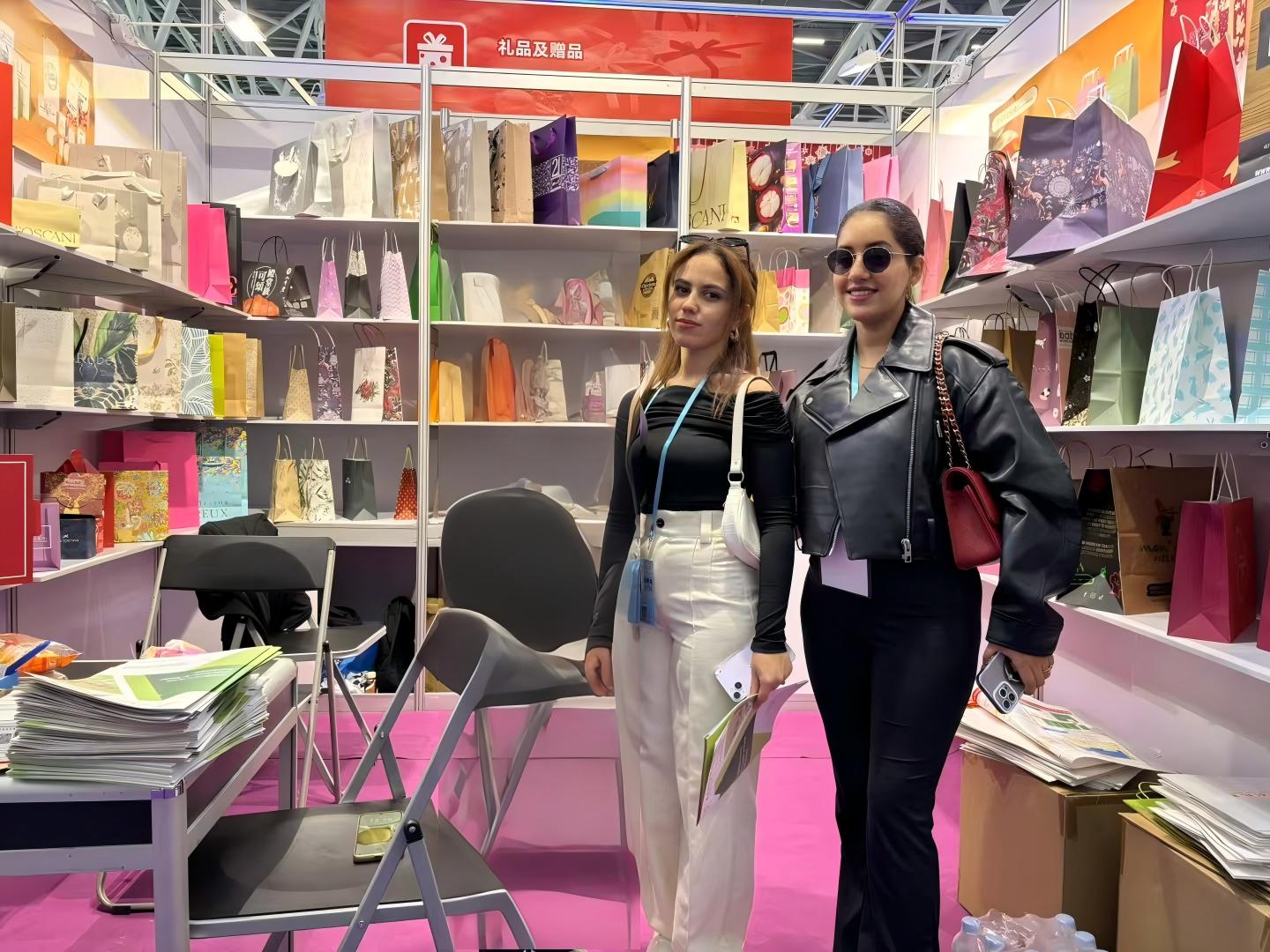 Two exhibition visitors viewing packaging samples at the XLY booth