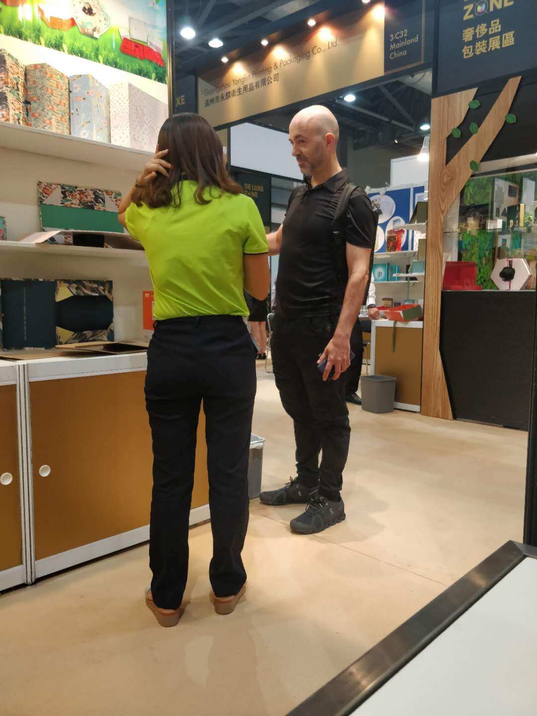 Packaging sample discussion with a visitor at an exhibition booth