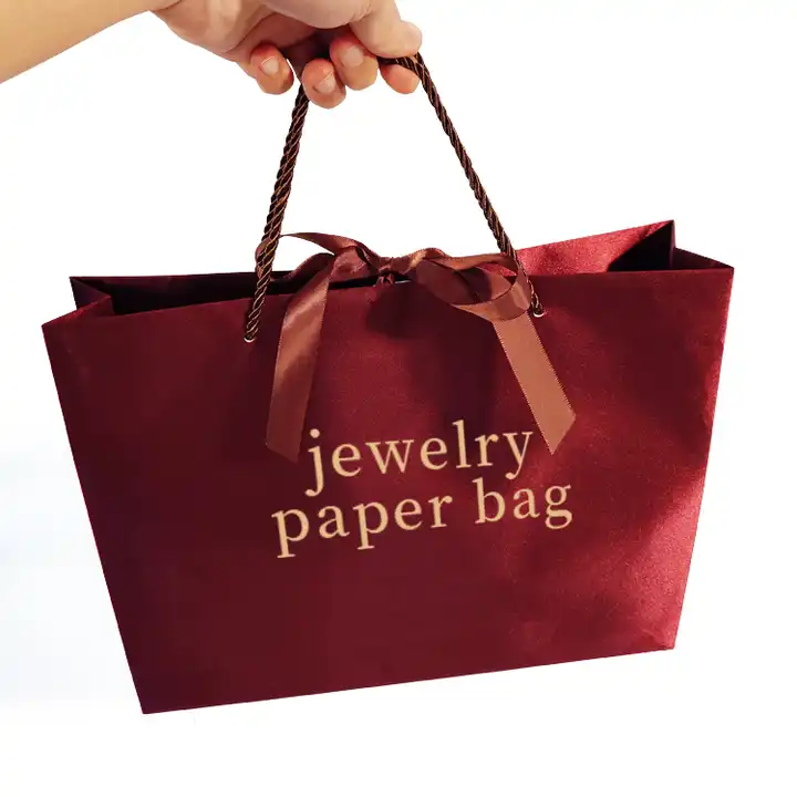 Burgundy paper gift bag with twisted rope handles and a satin ribbon bow