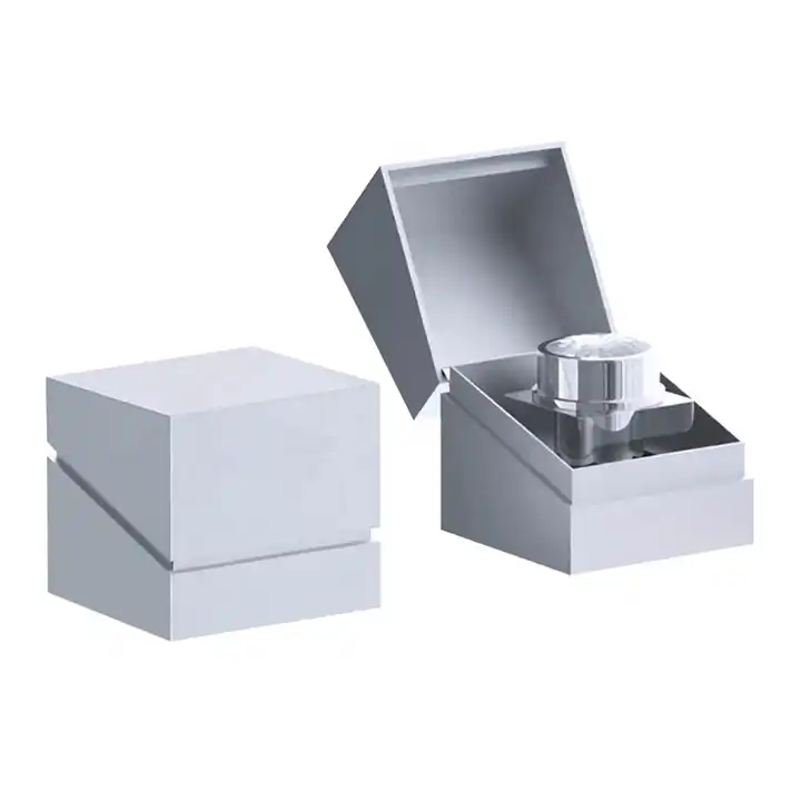 Open silver-gray cosmetic box with a small jar held in a fitted insert