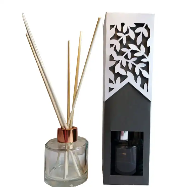 Reed diffuser beside a black and white display carton with leaf-shaped cutouts and a product window