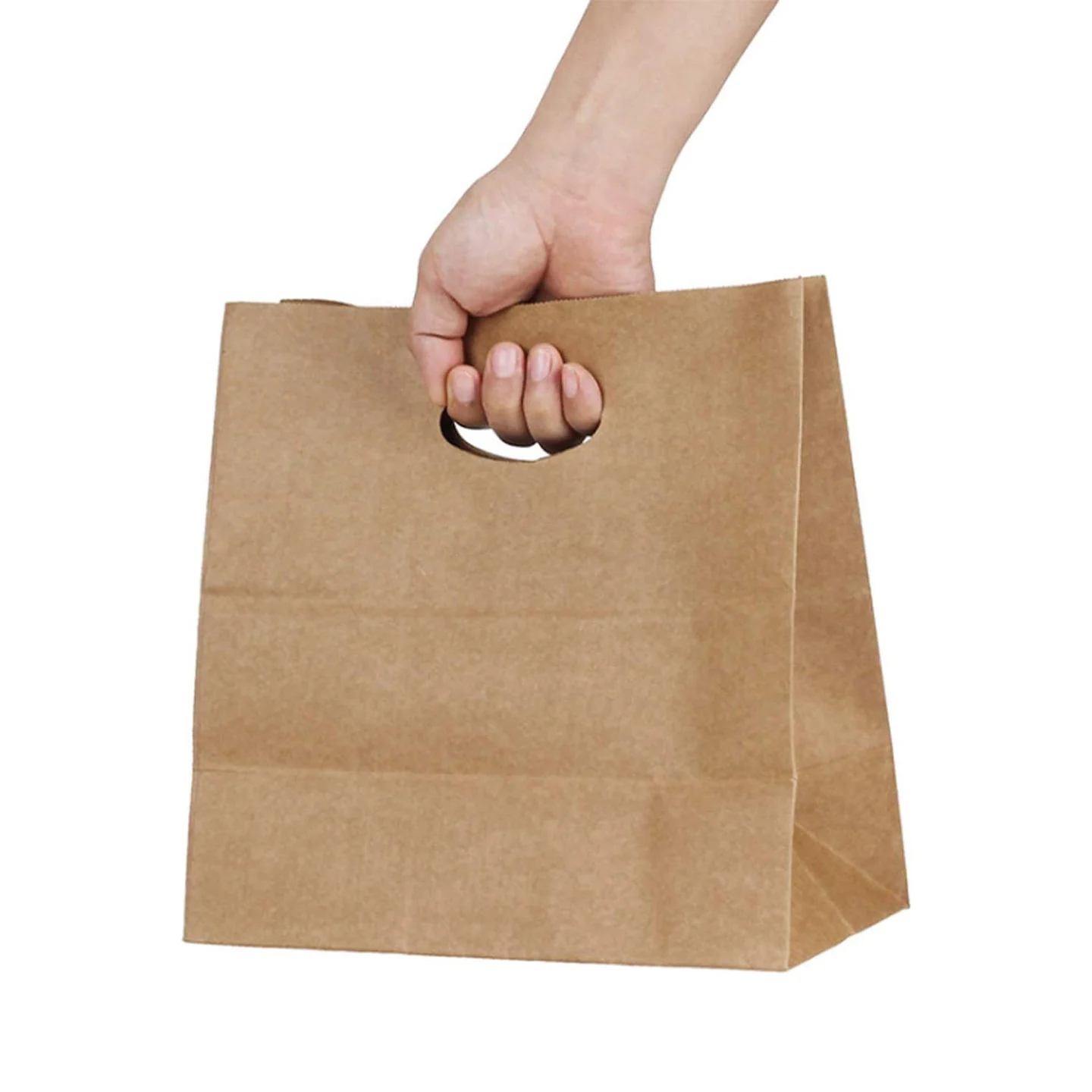 Hand carrying a kraft paper bag through an oval die-cut handle