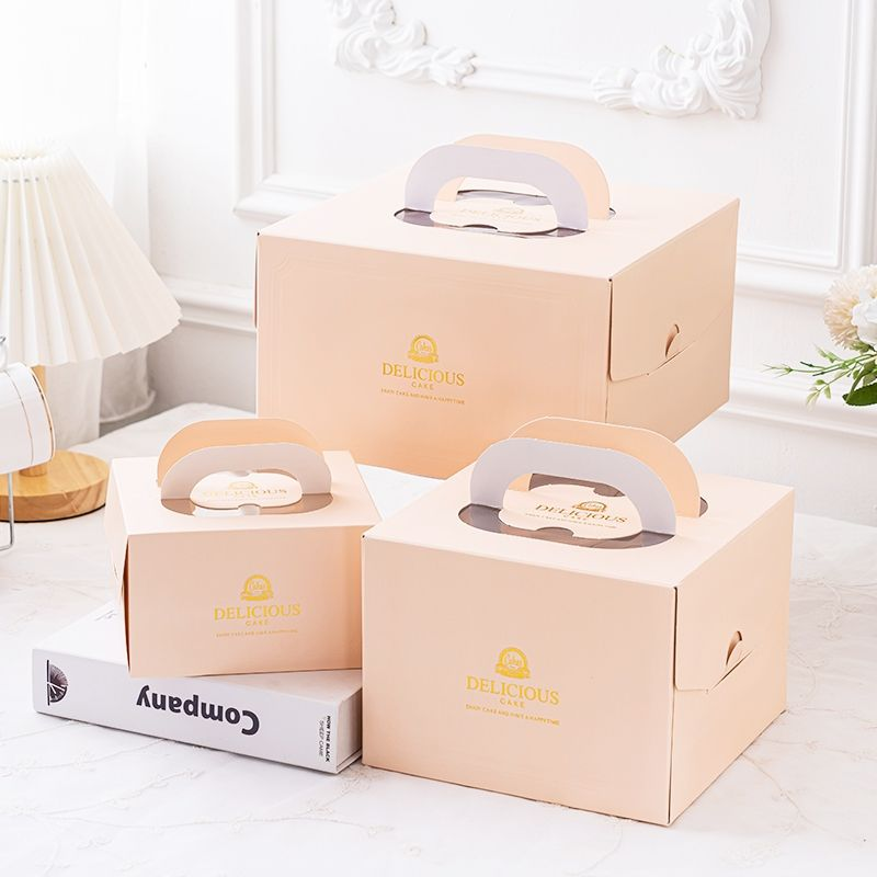 Peach-colored cake boxes with paper carry handles in three sizes