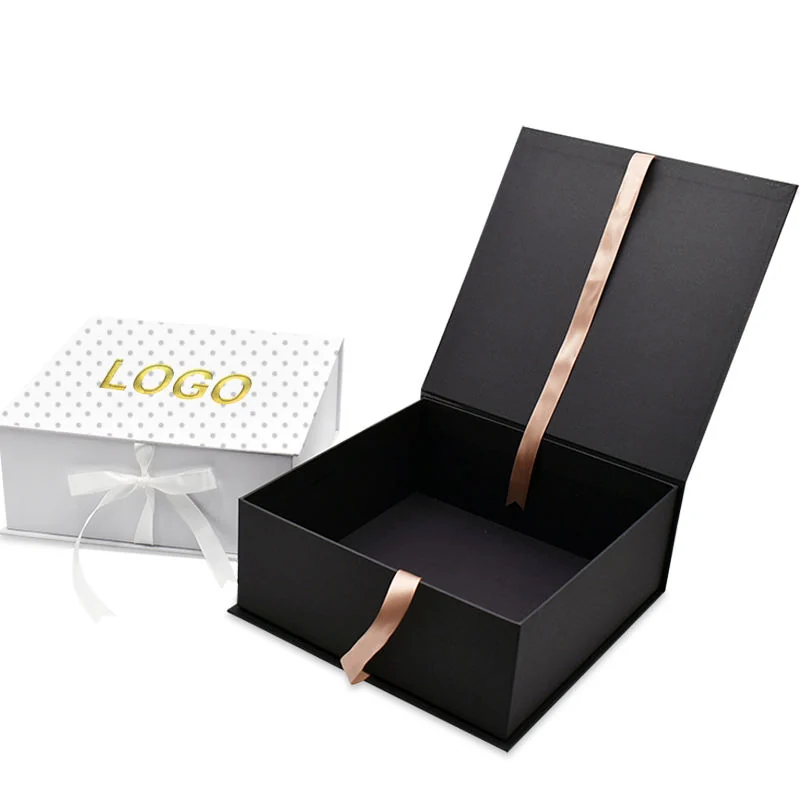 Open black folding gift box with a ribbon and a white printed gift box